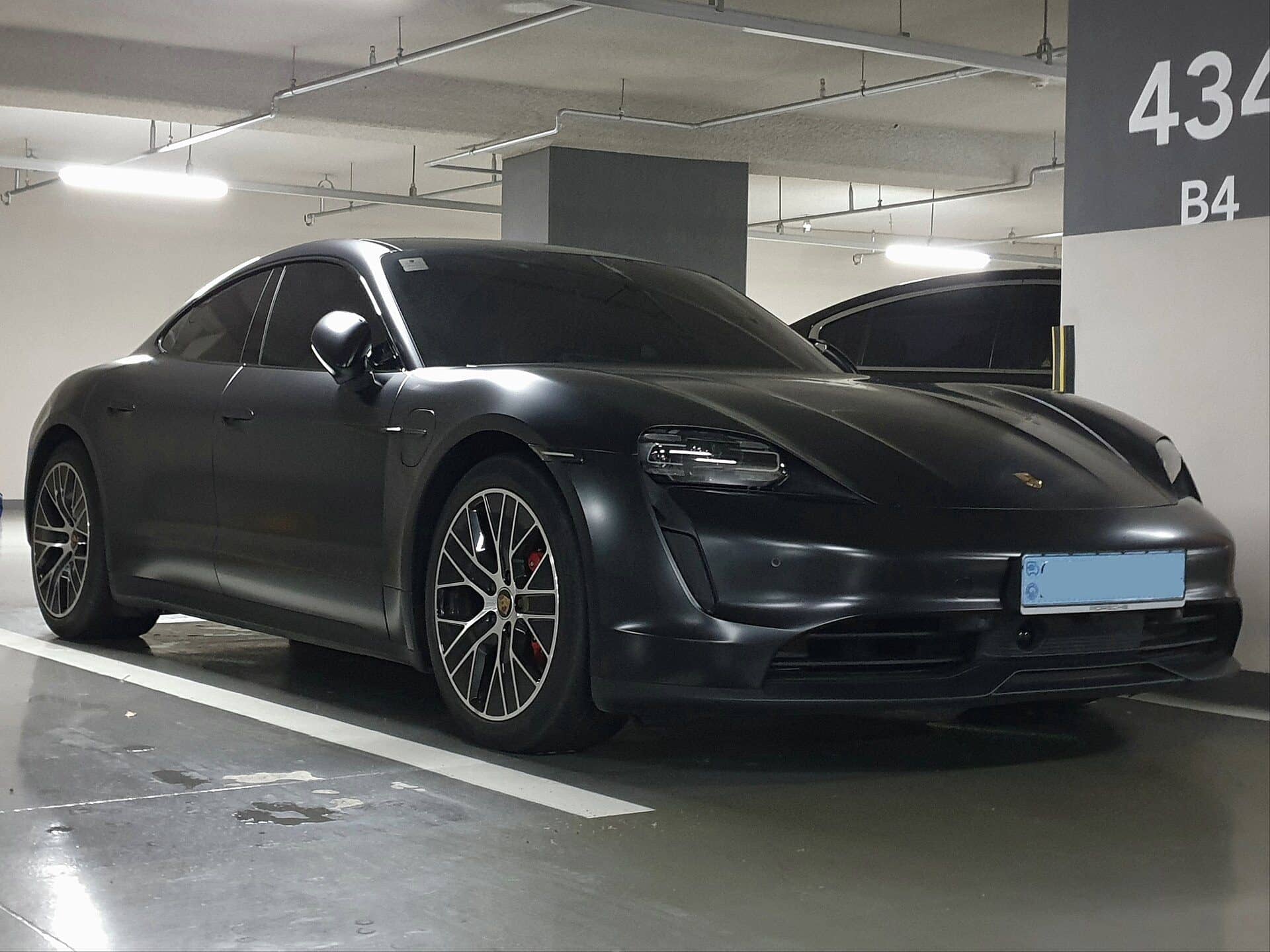 Porsche Taycan noire vue de trois quarts avant